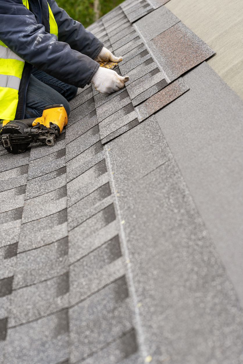 Pose de bardeaux sur une toiture résidentielle lors de travaux de construction au Québec. Situation typique nécessitant une assurance responsabilité civile pour entrepreneurs.