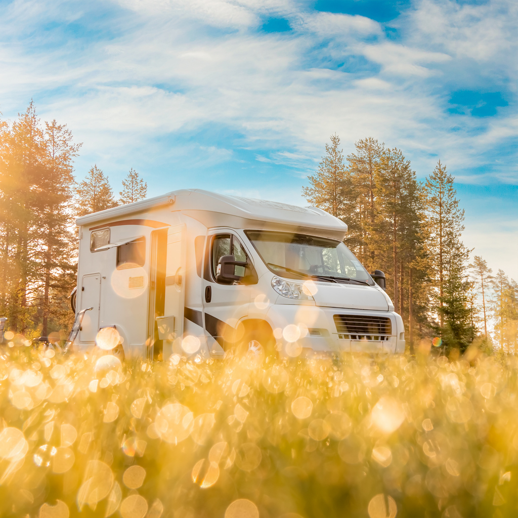 Autocaravane moderne installée dans un décor de plein air lumineux. Exemple de caravane nécessitant une assurance adaptée aux activités récréatives.