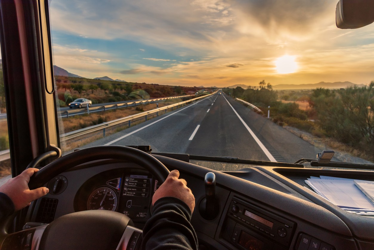 Conducteur sur l’autoroute avec vue sur un paysage naturel, représentant les services d’assurances au Québec pour transport et mobilité professionnelle.