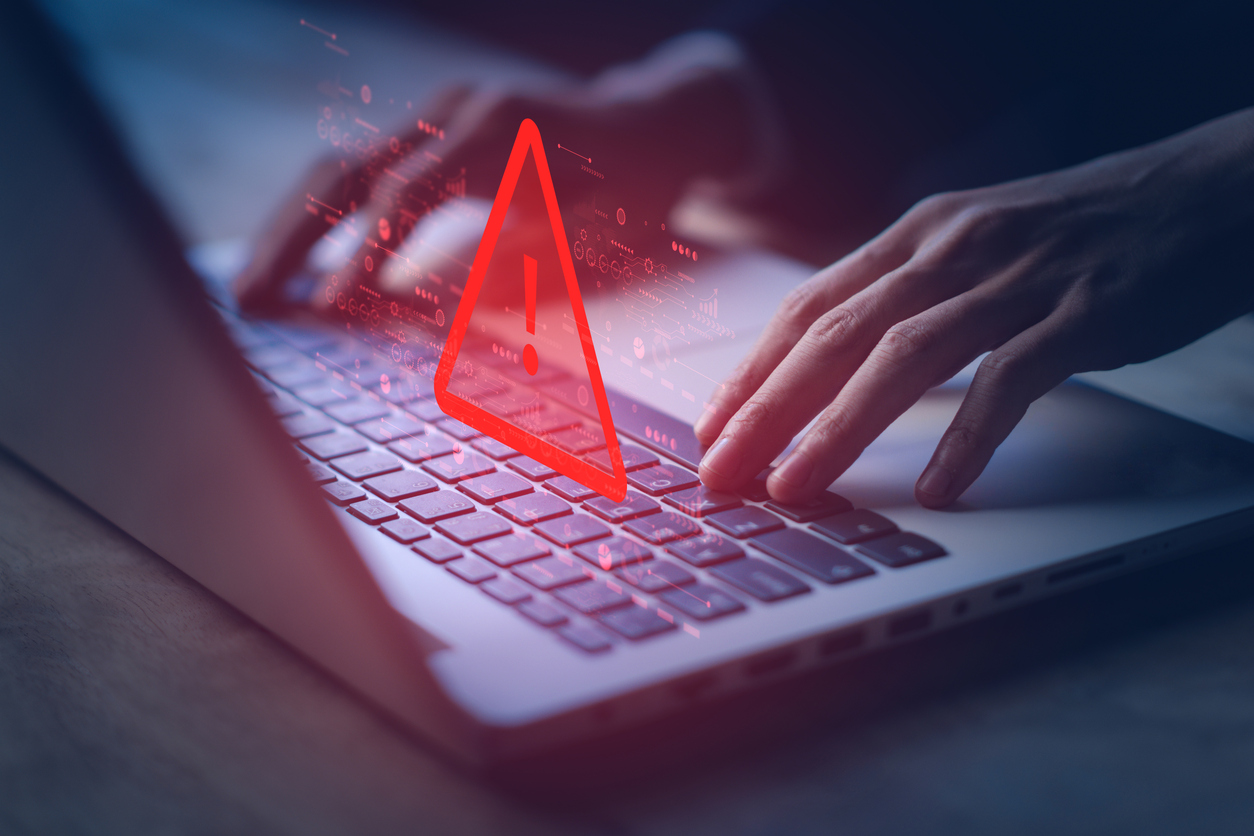 Saisie sur un ordinateur portable accompagnée d’une alerte visuelle rouge, mettant en contexte la protection contre les cyberrisques et l’assurance au Québec.