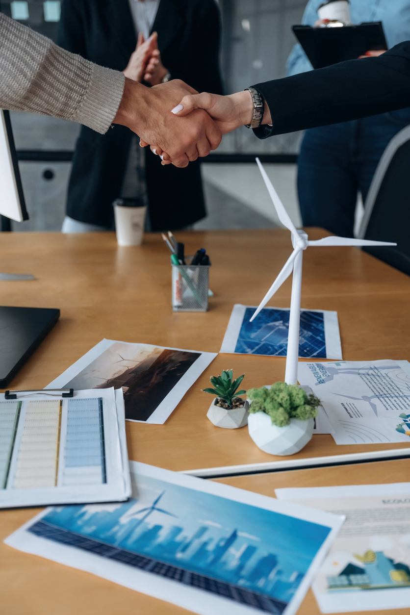 Deux professionnels concluant un accord sur un bureau avec dossiers, en lien avec la gestion des risques financiers et les assurances pour investisseurs au Québec.