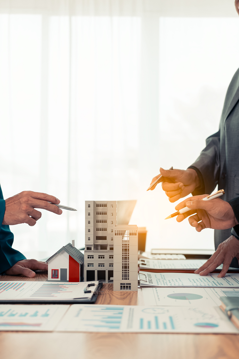Analyse d’un projet immobilier autour de maquettes d’immeubles et de documents financiers. Contexte lié à l’assurance immeuble et à la responsabilité civile des propriétaires fonciers au Québec.
