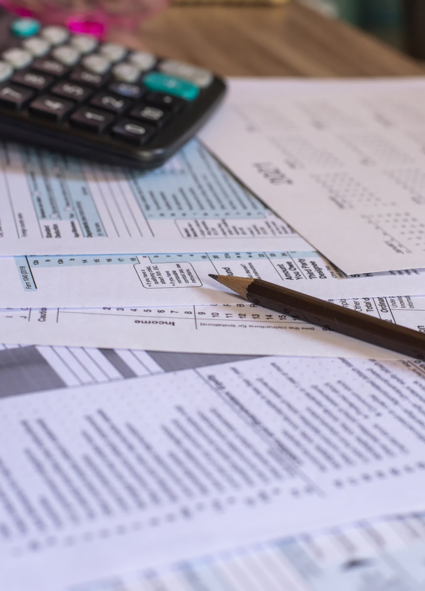 Documents, calculatrice, cahier et crayon sur un bureau, illustrant la gestion financière et les assurances commerciales au Québec pour entreprises.