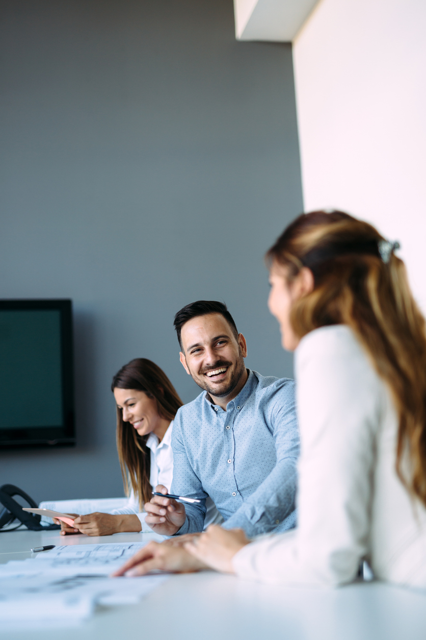 Collaborateurs d’une entreprise d’assurance en discussion lors d’une réunion interne au bureau. Contexte de services et d’expertise en assurances au Québec.
