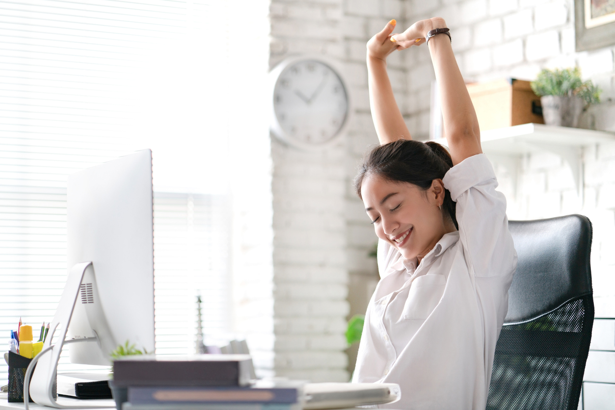 Femme s’étirant à son poste informatique pour prévenir les troubles musculosquelettiques, liée à la gestion des risques et à l’assurance responsabilité professionnelle au Québec.