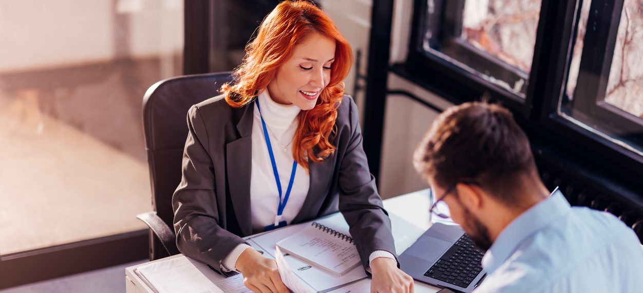 Insurance broker presenting policy documents to a client during a consultation meeting.