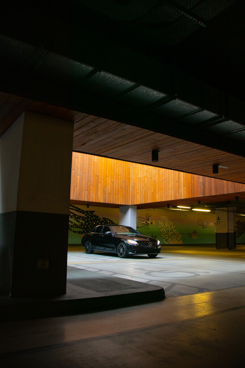 Black C-Class in a modern parking garage with artistic murals